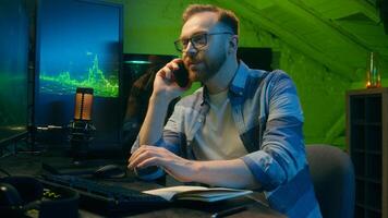 Smiling happy Caucasian broker man guy developer crypto businessman discussing mobile phone at home neon trader male work computer nighttime freelancer business good result thumb up sign stock trade photo