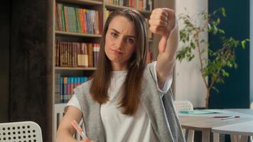 Upset dissatisfied Caucasian woman teacher student showing thumb down refusal dislike school female educator disapproval learning negative gesture reject bad university no girl study library college photo