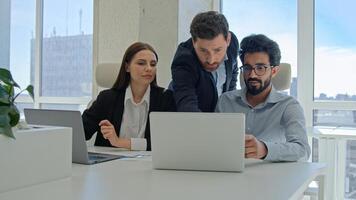 Diverse team corporate coworkers working laptops in office male business coach mentor boss businessman helping employees with computer work training new workers help interns check explain data project photo
