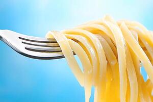 Close-up of fork with appetizing spaghetti on blue background photo