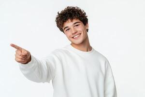 Smiling young man pointing finger at copy space isolated on white background. photo