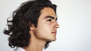 Young man with curly hair looking away on white background. photo