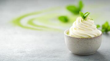 Creamy matcha dessert with mint garnish on textured surface photo