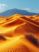 A stunning desert landscape with vibrant orange dunes and a distant mountain backdrop. photo