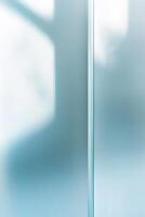 Frosted glass panels with a light blue tint diffuse soft light across a smooth surface, enhancing the minimalistic atmosphere and emphasizing tranquility photo