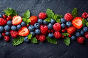 Fresh Summer Berries and Mint Spread on Black Stone - Perfect for Healthy Recipes and Food Decor photo