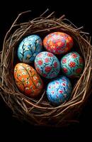A nest of eggs with flowers painted on them. The eggs are of different colors and sizes, and they are arranged in a basket. The basket is made of twigs, and it is placed on a black background photo