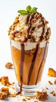 A glass of ice cream with a green leaf on top. The ice cream is topped with chocolate sauce and has a brown swirl photo