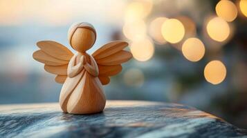 A wooden angel is sitting on a surface, with its wings spread out. The angel is praying, and the scene has a peaceful and serene mood photo