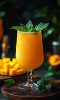 Mango mint cocktail delight. A vibrant mango cocktail features fresh mint, served elegantly in a glass with chunks of mango in the background. photo