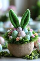A basket of Easter eggs with a green bunny on top. The basket is filled with eggs of different colors, including pink, green, and white. The bunny is made of green material and has a green tail photo