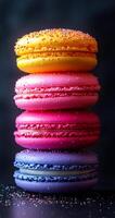 A stack of colorful macarons with sprinkles on top. The macarons are arranged in a pyramid shape, with the pink one on the bottom and the yellow one on top. Concept of indulgence and sweetness photo