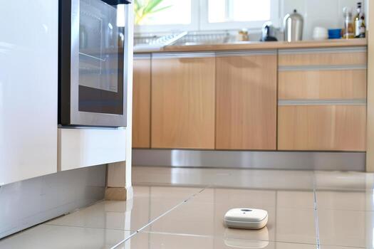 Smart home cleaning with a robotic vacuum in a modern kitchen setting photo