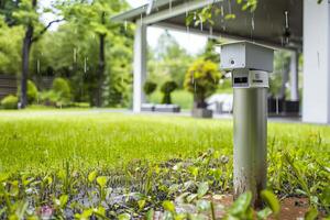 Smart rain sensor in a lush garden setting with modern pergola for weather monitoring photo