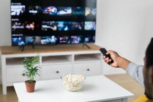 Remote control is pointed toward the television screen, control and choice of tv entertainment. TV, series and streaming service concept photo