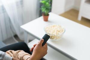 Remote control is pointed toward the television screen, control and choice of tv entertainment. TV, series and streaming service concept photo