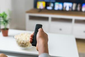 Remote control is pointed toward the television screen, control and choice of tv entertainment. TV, series and streaming service concept photo