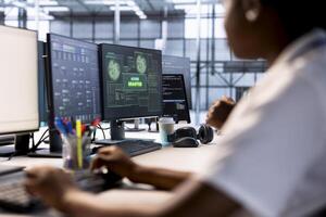 Woman in server farm getting access granted notification on PC screen, managing to access server files after they were locked by hacker using ransomware, receiving aid from IT staff members photo