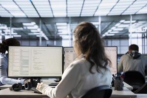 Technician in server hub ensuring valuable data remains shielded from potential threats using PC. Employee safeguarding data center against unauthorized access and vulnerabilities photo