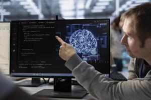 Manager overseeing programmers using artificial intelligence technology to optimize data center. Supervisor checking progress done by worker in server hub using AI tech to streamline operations photo
