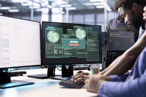 Computer scientist in data center getting access denied notification on PC screen, trying to access server files after they were locked by hacker using ransomware, requesting help from IT expert photo