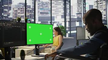 Man with disability in inclusive workplace working with machine learning tech on green screen computer. African american IT expert with paraplegia in wheelchair works with data on mockup PC, camera B photo