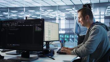 IT technician looking at PC screen, working in network security data center, ensuring optimal performance. Man supervising server hub, monitoring energy consumption across rigs, camera B photo