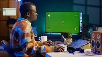 African american man using AI to develop a software system with chroma key on pc, cloud computing. Male IT programmer showing his skill in coding and cyber security, machine learning. Camera A. photo