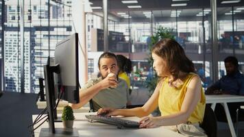 Man with paraplegia drinking coffee, checking progress done by employee doing code review to fix bugs. Worker code, being supervised by manager in wheelchair enjoying beverage, camera B photo