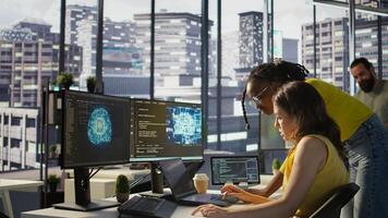 Admin assisted by coworker while utilizing cloud computing resources to train large scale machine learning models. Woman and colleague monitoring AI company systems using computer, camera B photo