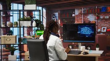 Admin uses computer for artificial intelligence computing simulation, waiting for code to finish compiling. African american woman works with AI deep neural networks at home, camera A photo