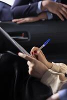Car dealership salesperson preparing purchase paperwork and documentation after agreeing terms with customer during test drive. Close up of showroom employee giving sale contract for client to sign photo