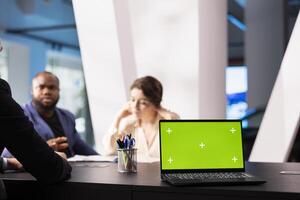 Salesman in dealership using green screen laptop, negotiating price and extra car features to help solidify deal. Agent persuading hesitant customers to buy vehicle using mockup notebook photo