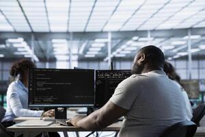 Data center employee using PC to find misconfigurations affecting rackmounts performance. Man checking servers bottlenecks leading to sluggish data transfer rates and malfunctions photo