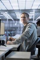 Portrait of upbeat engineer inspecting server rows in data center. Cheerful man supervising supercomputers providing processing and memory resources for various workloads photo