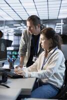 Worker requesting help from senior engineer to fix error in high tech AI data center. Employee in need of aid from IT specialist to repair artificial intelligence supercomputers photo