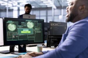 Software developer in data center getting access granted notification on PC screen, managing to access server files after they were locked by hacker using ransomware virus to blackmail company photo