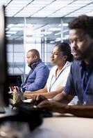 Smiling data center engineer next to colleagues using programming languages to construct algorithms and build applications. Cheerful server hub employee debugging and optimizing code photo