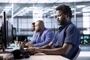 Cybersecurity division employee monitoring security incidents affecting server hub network. Software developer in data center office protecting company critical infrastructure from cyber threats photo