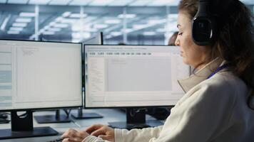 Engineer typing on computer in server hub, checking recovery plan, monitoring data center energy consumption, listening music. Technician wearing headphones inspecting rackmounts, camera B close up photo