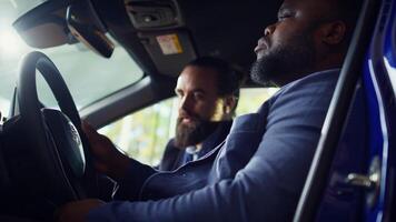 Man buying car, doing test drive to make sure everything is in good working order. African american driver examining vehicle, looking at characteristics and possible faults, camera B photo