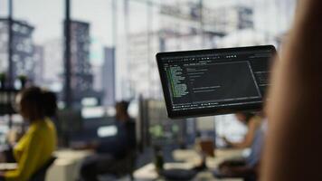 Data scientist uses tablet to check on machine learning models that can analyze data to automate decision making processes. Close up of IT specialist using device to do programming in office, camera B photo