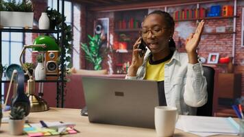 Irate manager in apartment berating employee during phone call, looking at laptop. Team leader scolding worker during telephone call after finding errors in documents, closing notebook in anger photo