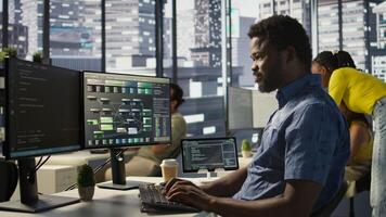 System administrator at work creating machine learning models that can process and analyze data. Close up of african american IT expert programming in office using PC, camera B photo