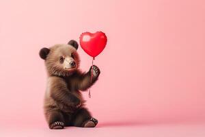 lovely brown bear cub holding red heart-shaped balloons on pastel pink background with copy space, romantic valentines day postcard photo