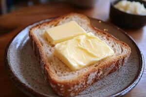 Fresh butter placed on a slice of fresh bread photo