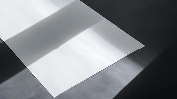 Abstract minimalistic composition of light and shadow on a blank sheet of paper set against a dark surface, creating a serene and peaceful atmosphere in photography photo