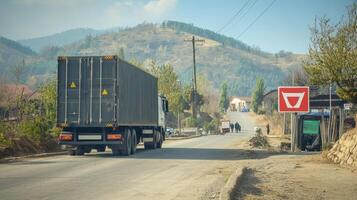 Truck Transporting Cargo on Mountainous Road with Caution Signage photo