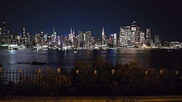 New York City Skyline at Night, A vibrant view of the illuminated New York skyline reflecting on water. video