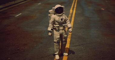Astro explorer walks on empty road in unusual urban setting at night video
